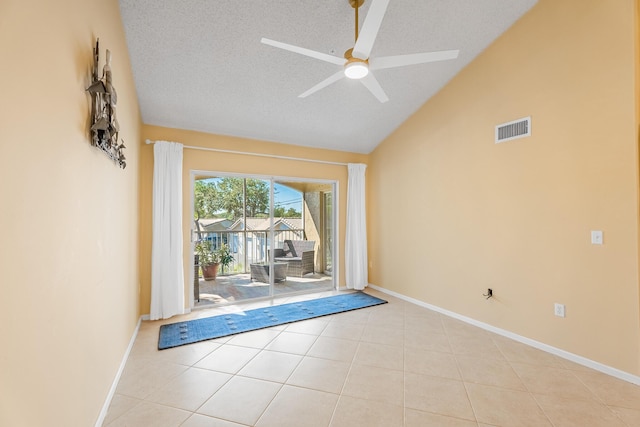 spare room with light tile patterned floors, a ceiling fan, visible vents, vaulted ceiling, and a textured ceiling