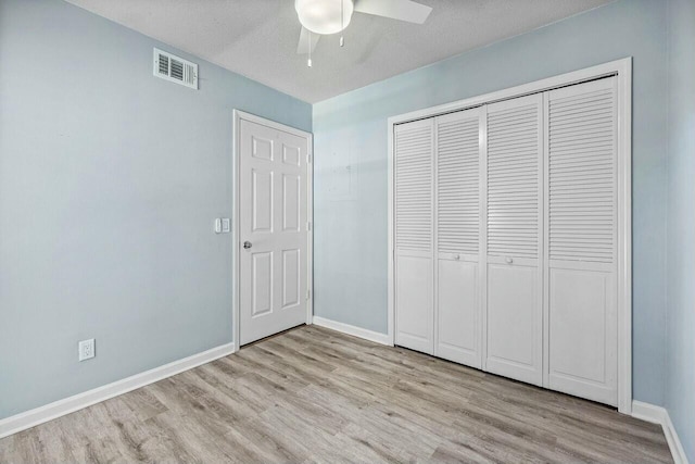 unfurnished bedroom with light wood-type flooring, visible vents, baseboards, and a closet