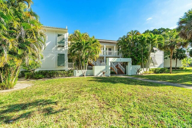 exterior space featuring a front lawn and stairs