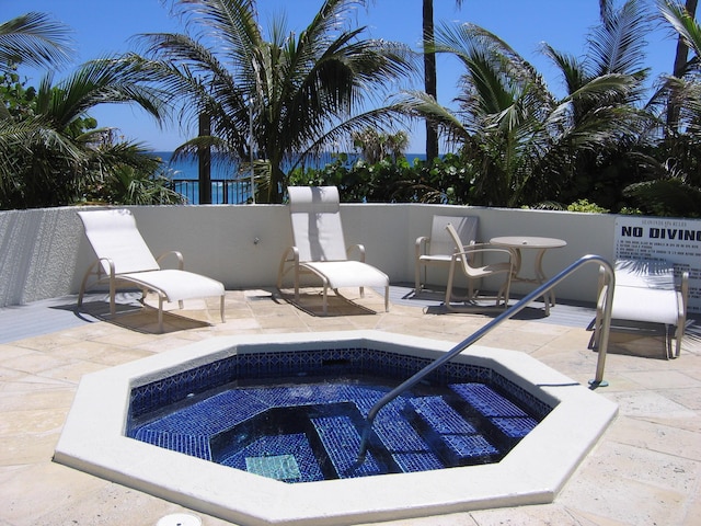 view of pool with a patio and a hot tub