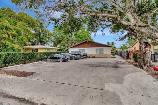 view of front of property with fence and uncovered parking