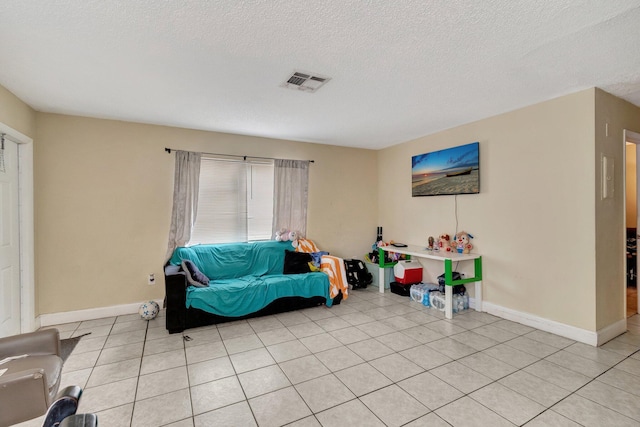 sitting room featuring light tile patterned flooring, baseboards, visible vents, and a textured ceiling