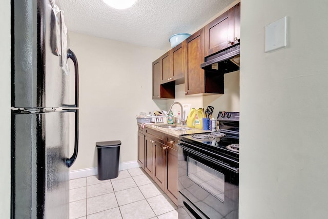 kitchen featuring black appliances, under cabinet range hood, light countertops, light tile patterned flooring, and a textured ceiling