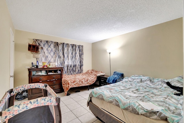 bedroom with light tile patterned flooring and a textured ceiling