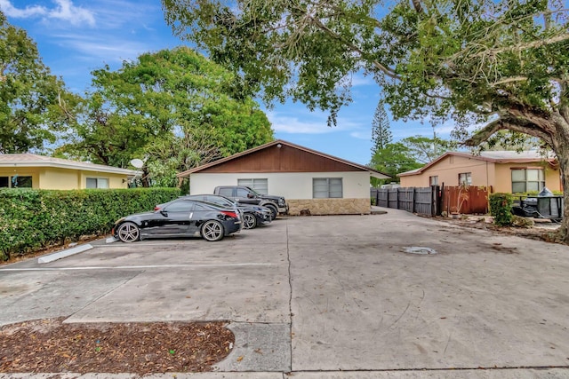 view of front of property with uncovered parking and fence