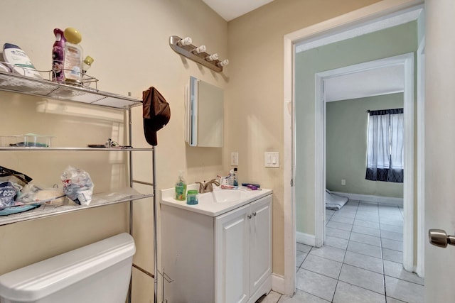 half bath with vanity, toilet, baseboards, and tile patterned flooring