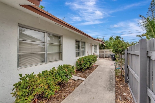 view of property exterior featuring stucco siding and fence