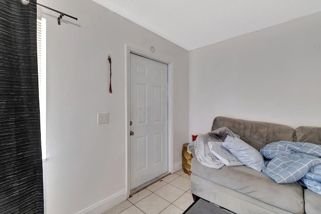 living room featuring light tile patterned flooring, baseboards, and a textured ceiling