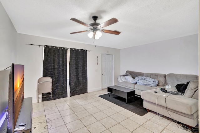 living room with baseboards, a textured ceiling, light tile patterned flooring, and a ceiling fan