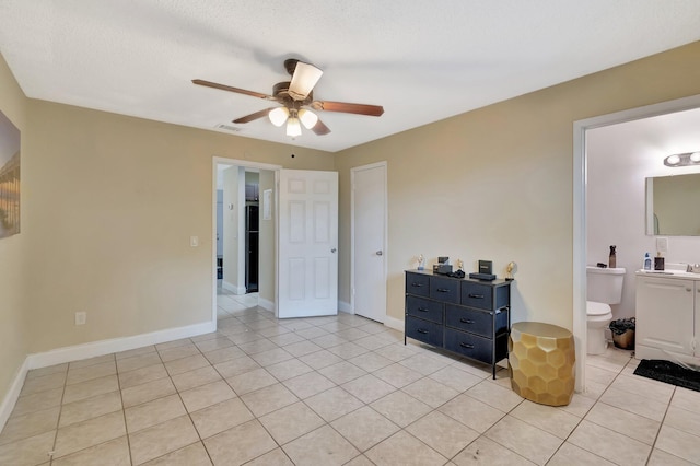 interior space featuring light tile patterned flooring, visible vents, baseboards, and a ceiling fan