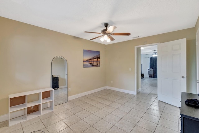 spare room featuring light tile patterned flooring, visible vents, and baseboards