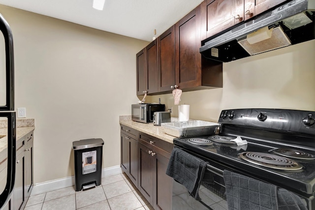 kitchen featuring under cabinet range hood, light tile patterned floors, black appliances, and dark brown cabinetry