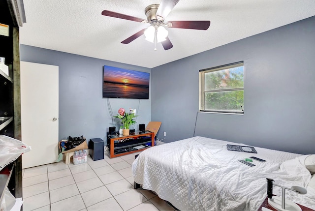 bedroom with light tile patterned floors, a textured ceiling, and a ceiling fan