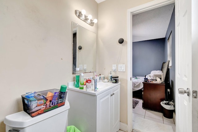 bathroom with vanity, ensuite bath, tile patterned flooring, a textured ceiling, and toilet