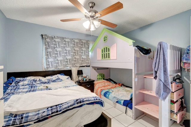 tiled bedroom with a ceiling fan and a textured ceiling