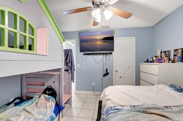 bedroom with light tile patterned floors, a ceiling fan, visible vents, a closet, and a textured ceiling