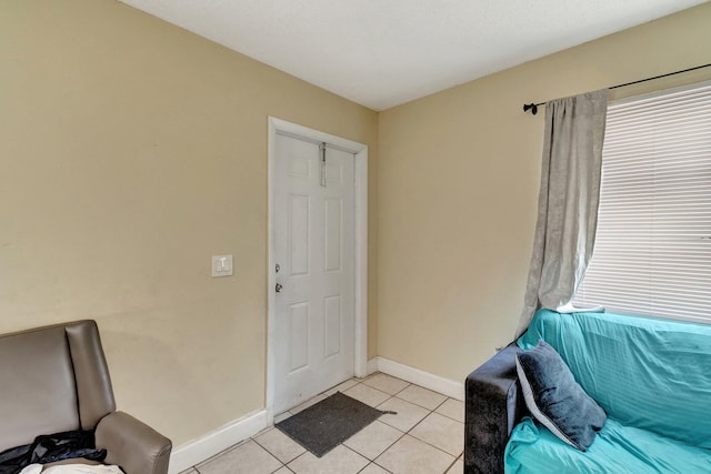 foyer entrance featuring light tile patterned flooring and baseboards