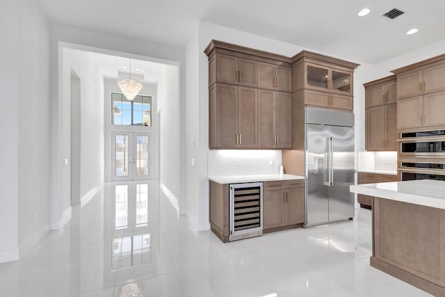 kitchen featuring visible vents, beverage cooler, recessed lighting, stainless steel appliances, and light countertops