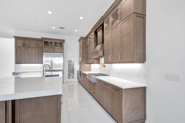 kitchen with glass insert cabinets, visible vents, appliances with stainless steel finishes, and a sink