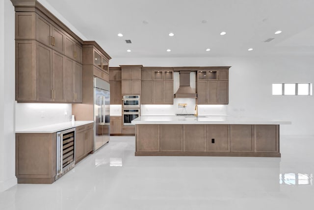 kitchen featuring visible vents, custom range hood, stainless steel appliances, wine cooler, and light countertops