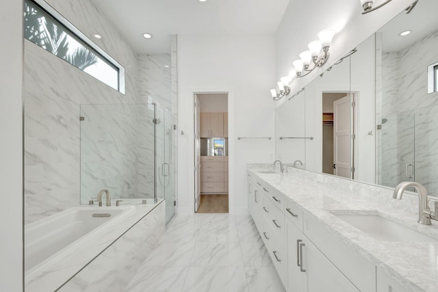 full bathroom featuring a bath, marble finish floor, a marble finish shower, and a sink