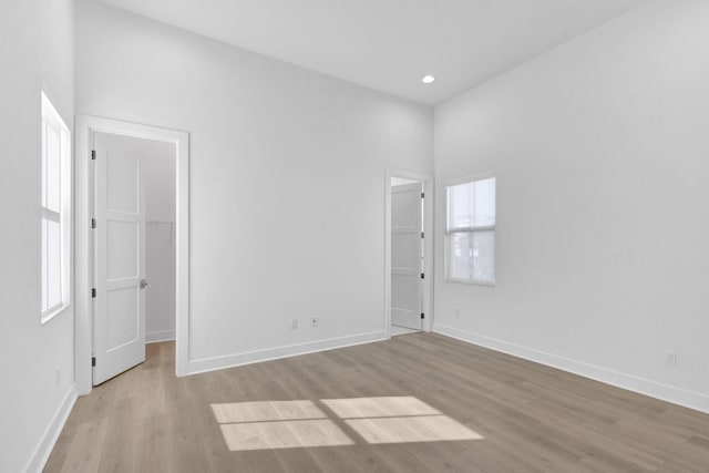 empty room featuring recessed lighting, light wood-type flooring, and baseboards