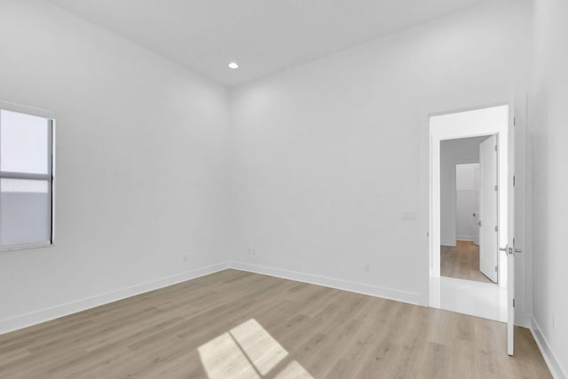 empty room featuring recessed lighting, light wood-type flooring, and baseboards