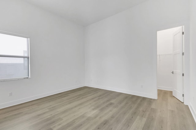 unfurnished room featuring light wood-style flooring and baseboards