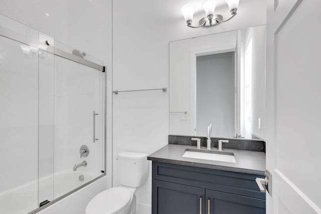 full bathroom featuring toilet, vanity, and bath / shower combo with glass door