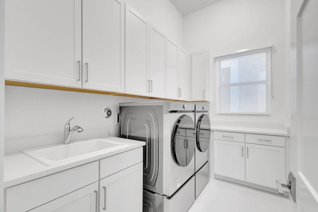 washroom with a sink, cabinet space, and washing machine and clothes dryer