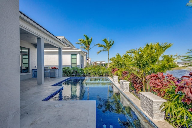 pool with a patio and an outdoor kitchen