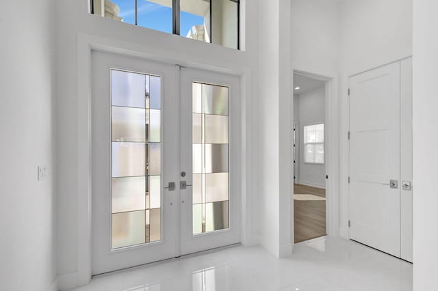 doorway to outside with tile patterned floors, french doors, and a towering ceiling