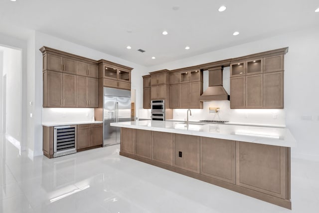 kitchen featuring premium range hood, beverage cooler, recessed lighting, appliances with stainless steel finishes, and a sink