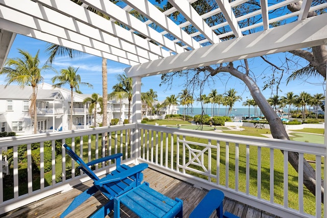 wooden deck with a yard and a pergola