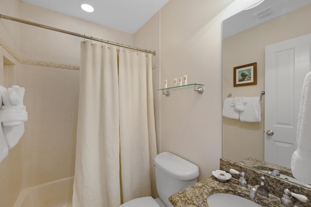 bathroom featuring vanity, shower / bath combo with shower curtain, toilet, and visible vents