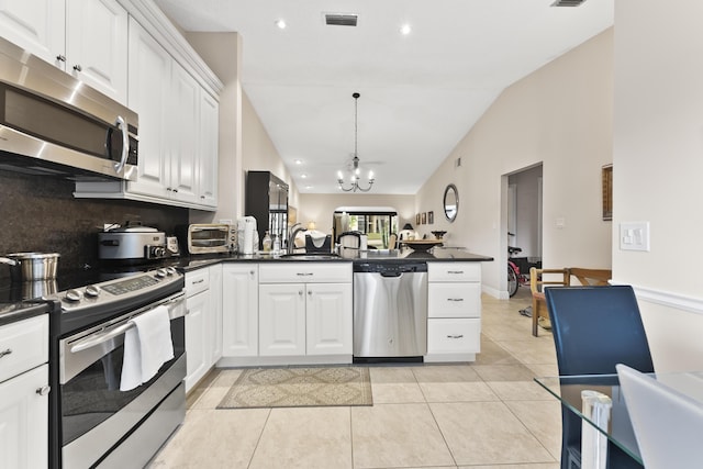 kitchen featuring visible vents, dark countertops, appliances with stainless steel finishes, and a peninsula