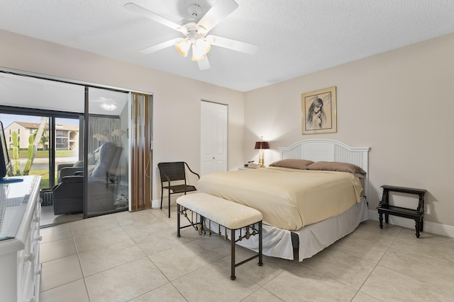 bedroom featuring a ceiling fan, baseboards, light tile patterned flooring, access to exterior, and a textured ceiling