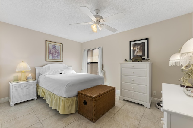 bedroom featuring light tile patterned floors, baseboards, and a textured ceiling