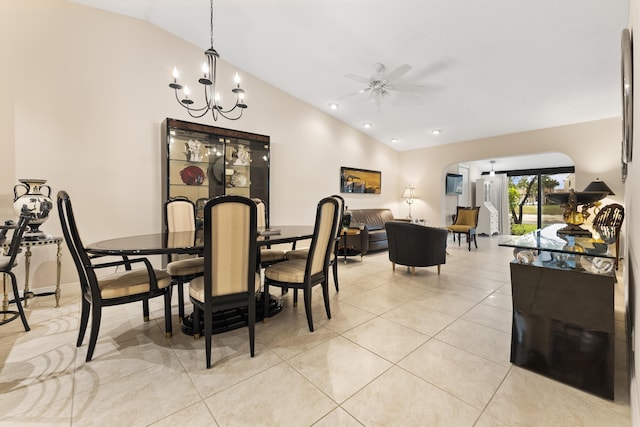 dining room with light tile patterned floors, ceiling fan with notable chandelier, and vaulted ceiling