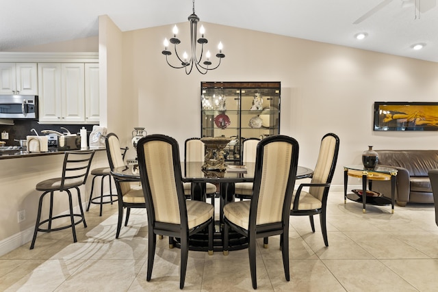 dining room with lofted ceiling, light tile patterned floors, ceiling fan with notable chandelier, and baseboards