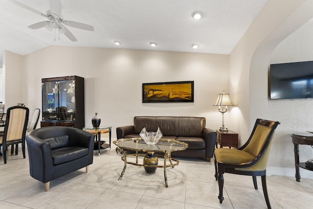 living room with light tile patterned floors, baseboards, lofted ceiling, arched walkways, and ceiling fan