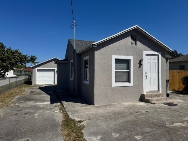 view of front of property featuring fence, driveway, stucco siding, entry steps, and a garage