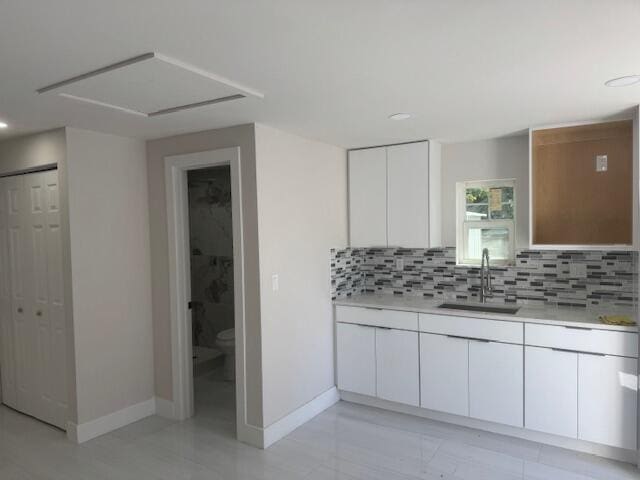 bathroom featuring decorative backsplash, baseboards, toilet, and vanity