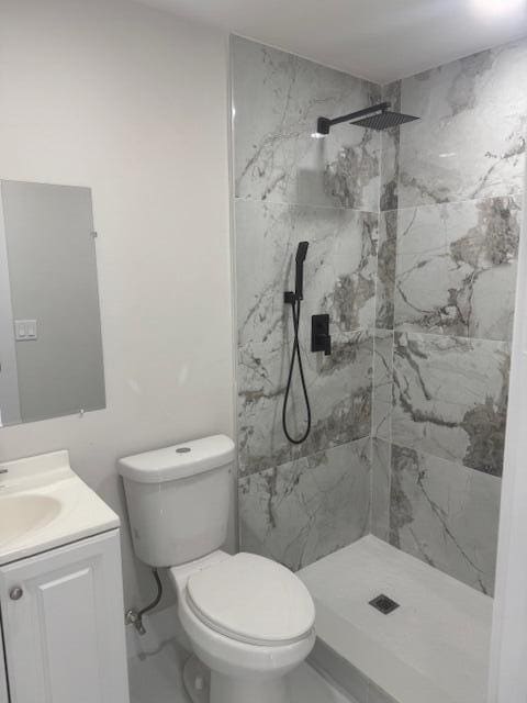 full bath with vanity, toilet, marble finish floor, and a marble finish shower