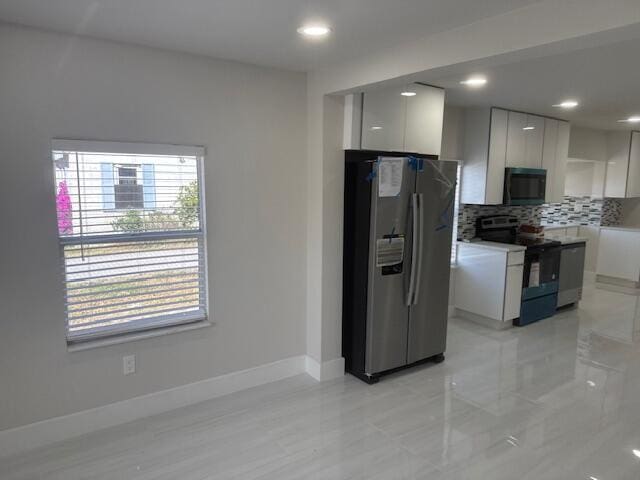 kitchen featuring backsplash, black microwave, stainless steel refrigerator with ice dispenser, electric range, and modern cabinets