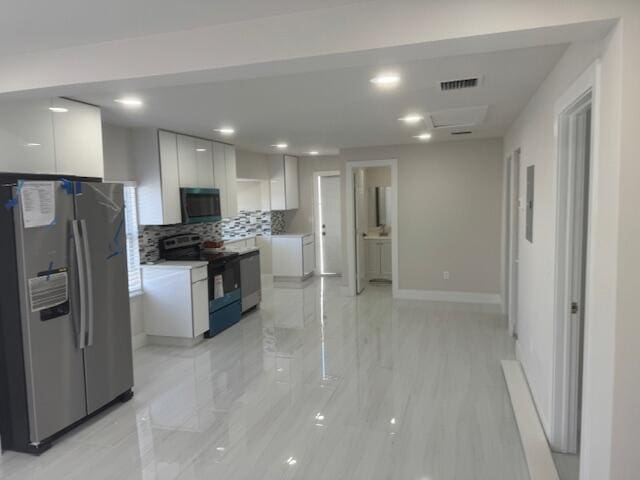 kitchen featuring electric range, visible vents, white cabinetry, stainless steel fridge, and black microwave