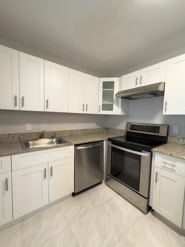 kitchen featuring a sink, under cabinet range hood, appliances with stainless steel finishes, white cabinets, and glass insert cabinets