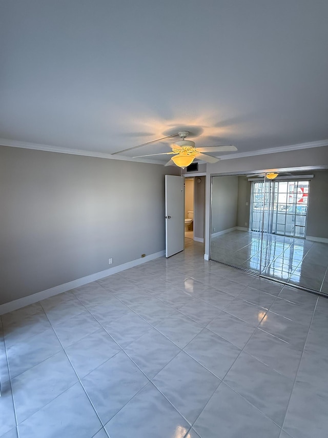 empty room with a ceiling fan, baseboards, and ornamental molding