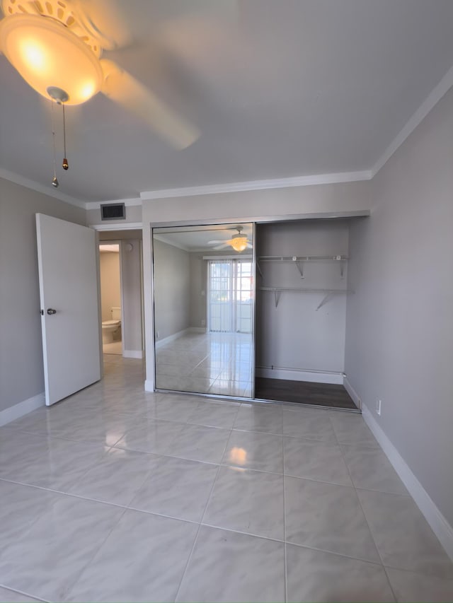 unfurnished bedroom featuring visible vents, baseboards, a closet, and crown molding