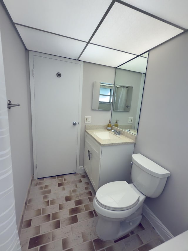 bathroom with vanity, toilet, and baseboards